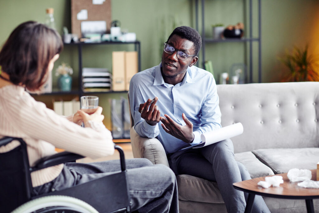 Black psychologist teaching a young woman with disability stress management and other coping skills.